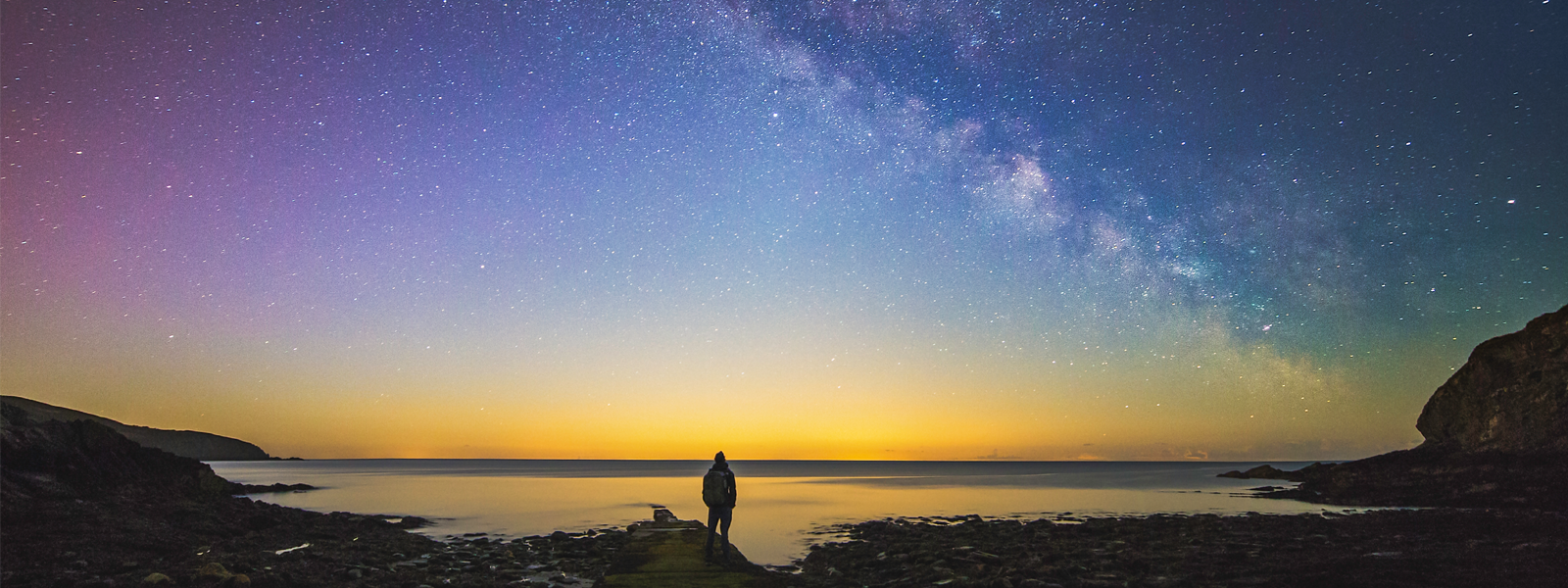 A man stood with his back to the camera gazing at an extraordinary display of stars on the Isle of Man.